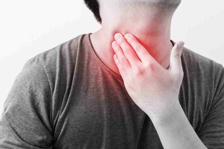 A man touches his tender thyroid, which radiates with a soft red glow