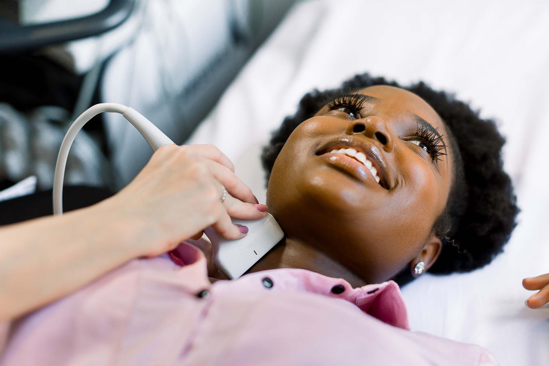 A young female patient receives a thyroid ultrasound