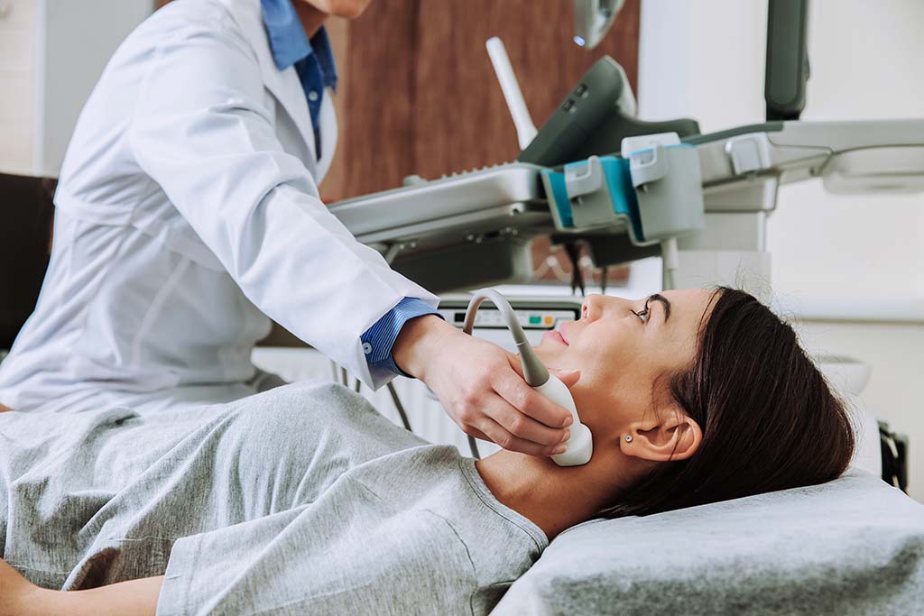 Side view of a patient receiving an ultrasound of the thyroid